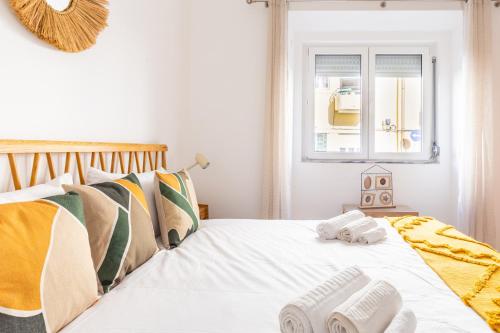 ein Schlafzimmer mit einem Bett mit Handtüchern darauf in der Unterkunft Wonderful Brand New Apartment Belém - A few steps away from the River! in Lissabon