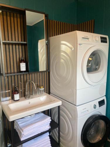 a bathroom with a washing machine and a sink at Kongenstofte house in Nakskov