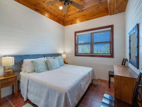 ein Schlafzimmer mit einem Bett und einer Holzdecke in der Unterkunft Lighthouse Point Resort # 5 in West Bay