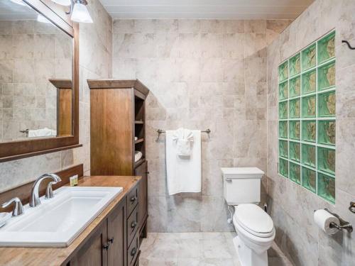 ein Badezimmer mit einem weißen WC und einem Waschbecken in der Unterkunft Lighthouse Point Resort # 5 in West Bay