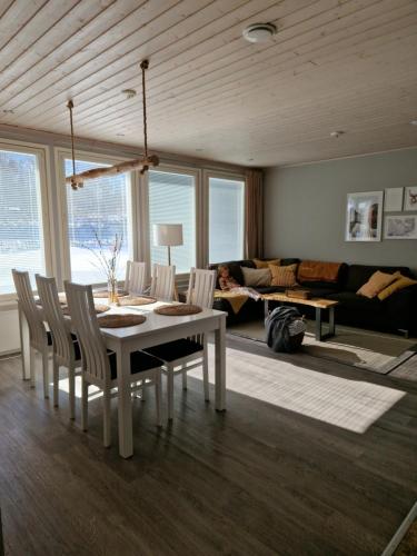 uma sala de estar com uma mesa branca e cadeiras em Omakotitalo hyvällä sijainnilla em Muurame