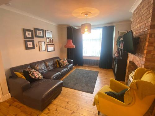 un soggiorno con divano e sedie in pelle di Three Bedroom Family home with garden in Walthamstow a Londra