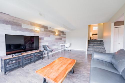 a living room with a couch and a flat screen tv at Cozy 5BD House in North Mission Crawford in Kelowna