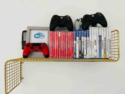 a shelf with video games and controllers on it at Luxury Villa 6BR with Swimming Pool by Beach - Villa Costa in Rishon LeẔiyyon