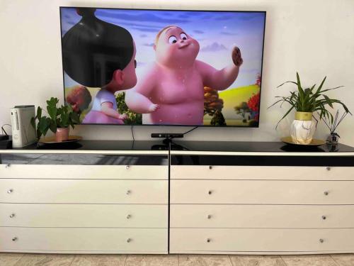 a flat screen tv sitting on top of a dresser at Luxury Villa 6BR with Swimming Pool by Beach - Villa Costa in Rishon LeẔiyyon
