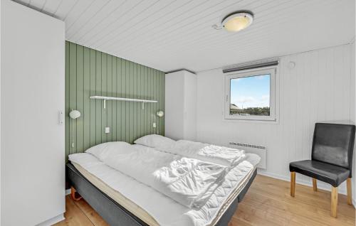 a bedroom with a bed and a chair in it at Lovely Home In Ringkbing With Wifi in Søndervig
