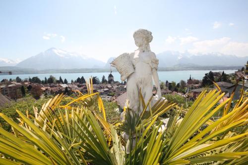 a statue of an angel standing on top of a hill at Otium-Oberhofen in Oberhofen am Thunersee
