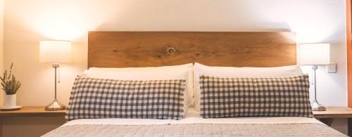 1 cama con 2 almohadas y cabecero de madera en Tetxe B&B Roncal en Roncal