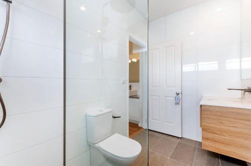 a white bathroom with a toilet and a sink at Southern Tides in Port Fairy