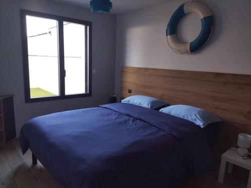 ein Schlafzimmer mit einem blauen Bett und einem Fenster in der Unterkunft gîte Belle-île in Plouhinec
