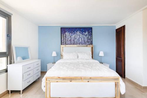 een slaapkamer met een wit bed en een blauwe muur bij Gateway For You And Your Loves Ones I Sleeps 6 in Santo Domingo