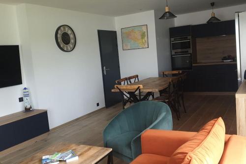 ein Wohnzimmer mit einem Sofa und einem Tisch in der Unterkunft gîte Belle-île in Plouhinec