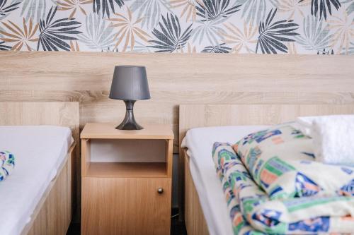 a bedroom with two beds and a lamp on a night stand at DW Turysta in Licheń Stary