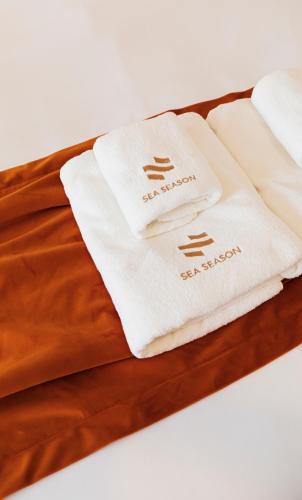 two white towels sitting on top of a bed at Sea Season Pool Villa Pattaya in Bang Lamung