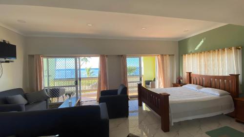 een slaapkamer met een bed en een woonkamer met een balkon bij Sky Lodge in Nuku‘alofa