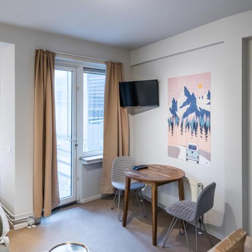a living room with a table and chairs and a window at Japie rooms - in the heart of Antwerp in Antwerp