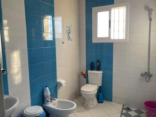 niebiesko-biała łazienka z toaletą i umywalką w obiekcie Grand appart avec vue sur mer w mieście Oued Laou
