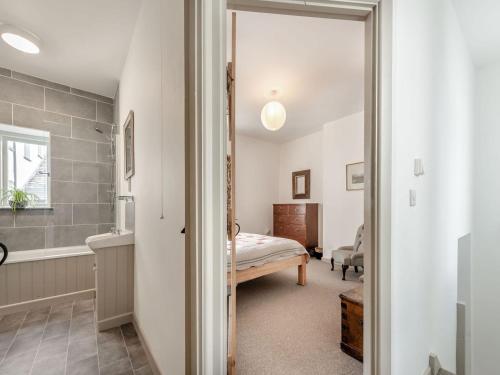 a bedroom with a bed and a bathroom at 1 Cromwells Cottage-uk40925 in Pembroke