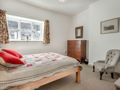 a bedroom with a bed and a chair and a window at 1 Cromwells Cottage-uk40925 in Pembroke