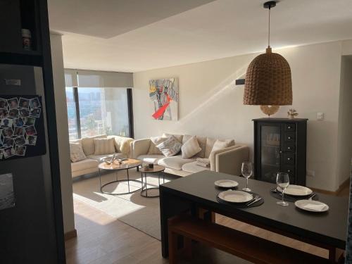 Santiago, Vitacura, amplio departamento في سانتياغو: غرفة معيشة مع أريكة وطاولة