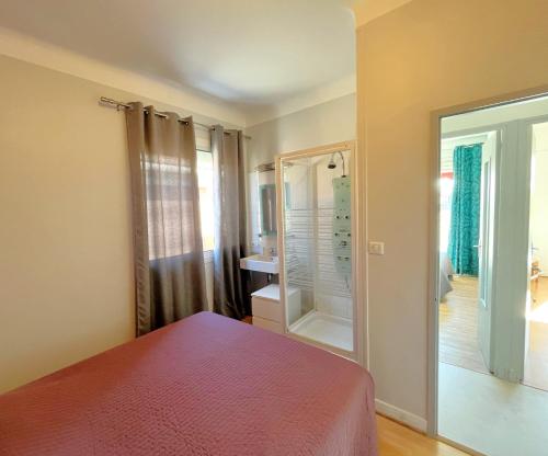 a bedroom with a bed and a mirror and a bathroom at Le Bellavista in Cassis