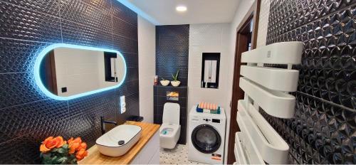 uma casa de banho com um WC, um lavatório e um espelho. em Apartament LIDER na wyłączność em Słupsk