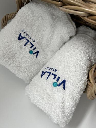 two towels in a basket with writing on them at Domek nad jeziorem in Myślibórz