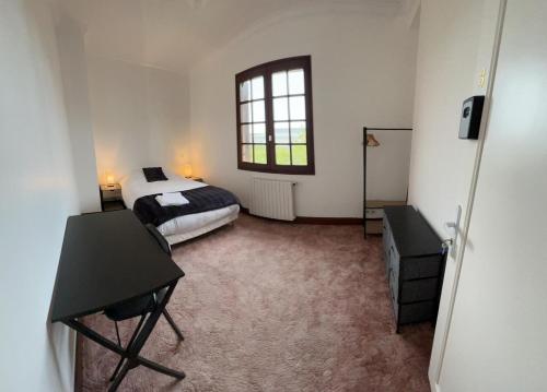 um quarto com uma cama, uma secretária e uma janela em Auberge Mer em Mer