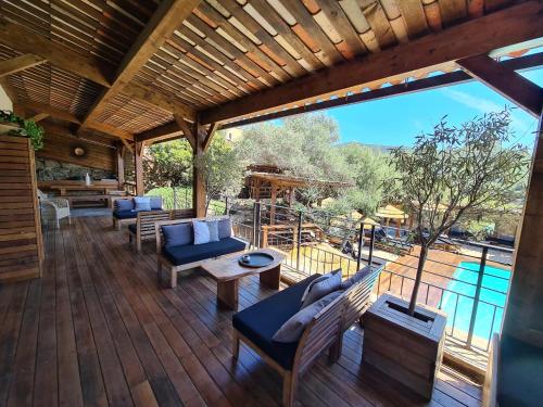 eine große Terrasse mit Sofas und einem Pool in der Unterkunft Chambre d'hôte Casa Maredda in Porticcio