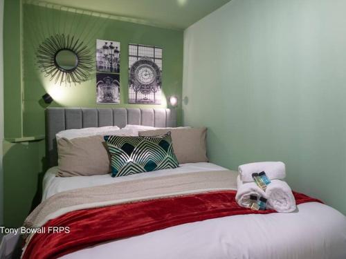 a bedroom with a bed with green walls and a mirror at Charming apartment next to Brighton Station in Brighton & Hove