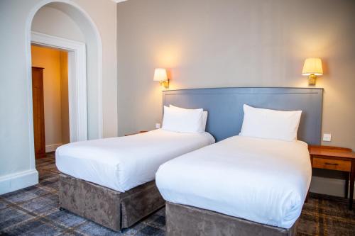 two beds sitting next to each other in a room at Arnos Manor Hotel in Bristol