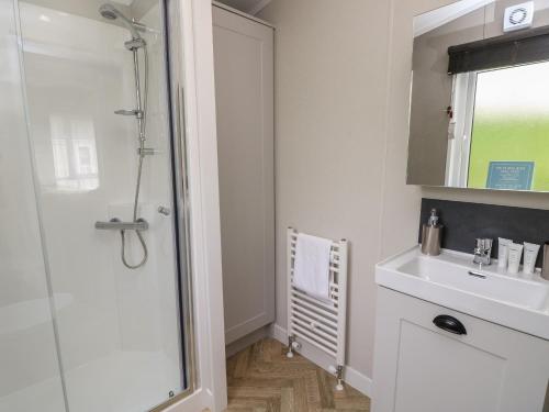 ein Bad mit einer Dusche und einem Waschbecken in der Unterkunft 48 Crosswinds in Bembridge