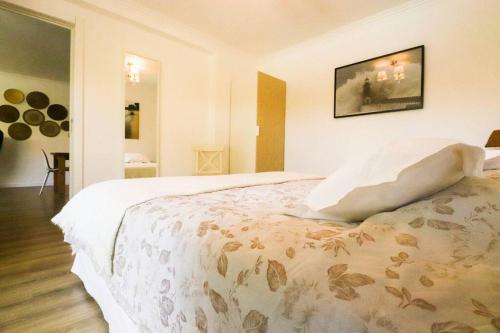 een slaapkamer met een groot wit bed en een deken bij Cascais Getaway with a shared pool in Cascais