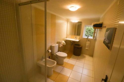 een badkamer met een toilet, een wastafel en een douche bij Cascais Getaway with a shared pool in Cascais