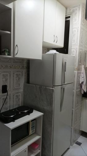 a kitchen with a white refrigerator and white cabinets at Ap no melhor lugar do Centro com elevador, wi-fi e Smart TV in Vitória