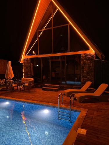 a swimming pool in front of a house at night at ROSE SAPANCA STONE HOUSE in Sakarya