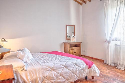 a bedroom with a bed and a mirror and a window at Borgo del Faggio - Case Vacanza in Montepulciano