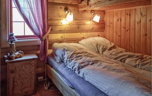 a bedroom with a bed in a log cabin at Gorgeous Home In Dlemo With Wifi in Åmli