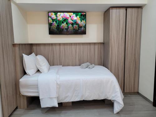 MaracayにあるApartaestudio 21 Detrás del Hyper Jumbo con planta eléctricaのベッドルーム1室(白いベッド1台、壁掛けテレビ付)