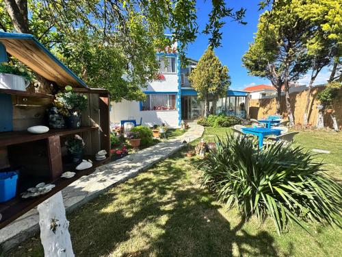 un patio con una casa y una mesa azul en Bonjourla Otel, en Urla