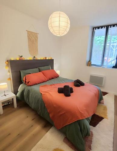 - une chambre dotée d'un lit avec des draps orange et vert dans l'établissement Le Terra Cotta - proche Hyper centre, à Montauban
