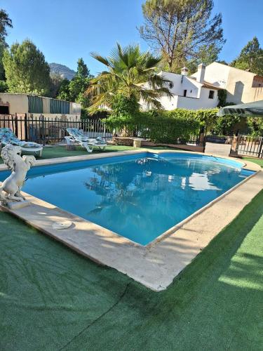 a swimming pool with blue water in a yard at VILLA EL SALADO -ALQUILER RURAL ISABEL in Arriate