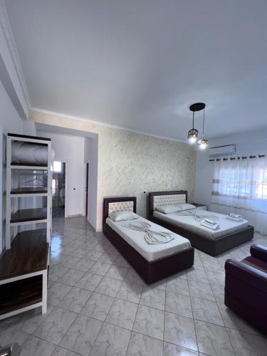 una camera con due letti e un divano di Hotel Frida a Himare