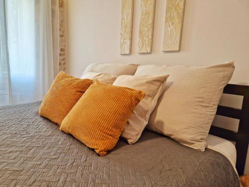a bed with four pillows on top of it at Hidden Oasis in Rovinj