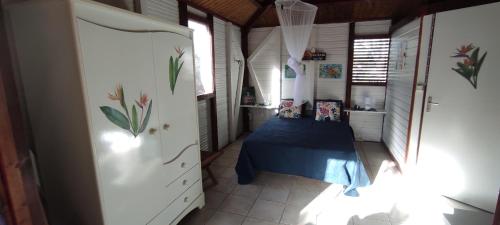 una camera con un letto in una piccola stanza di bungalow tout confort avec piscine à 5 mn de la mer a Saint-François