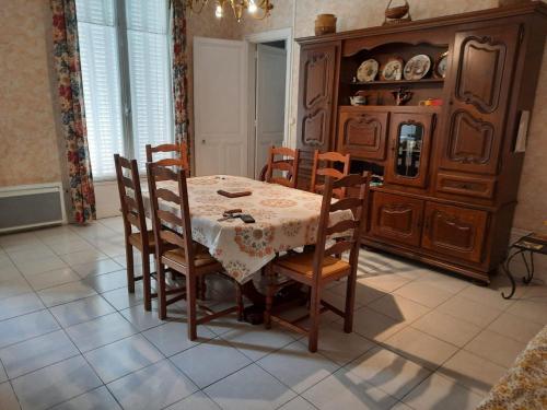 ein Esszimmer mit einem Tisch und Stühlen sowie einem Schrank in der Unterkunft APPARTEMENT PYRÉNÉE PALACE in Luchon