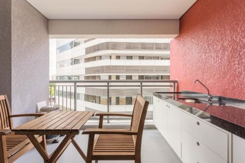uma cozinha com mesa e cadeiras e um edifício em Tabas - Edifício Z. Pinheiros em São Paulo