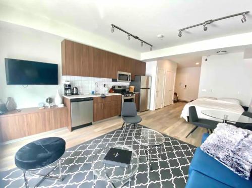 a large room with a bed and a kitchen with a kitchen at Perfect Brand New Studio Downtown Sidney in Sidney