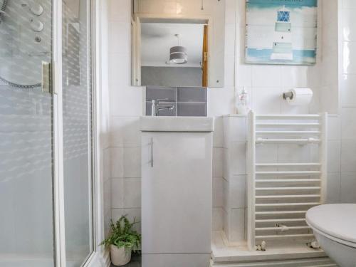 a small white bathroom with a sink and a toilet at Beach Cottage in Rhyl