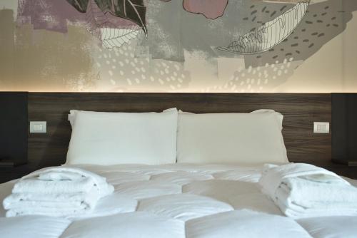 a white bed with white sheets and pillows on it at Royal Garden luxury rooms in Padova